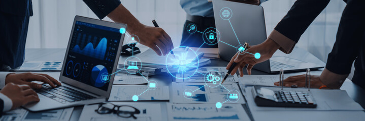 A modern business meeting showcases professionals collaborating with laptops and digital tools, visualizing data and strategies in a contemporary office setting. Trope