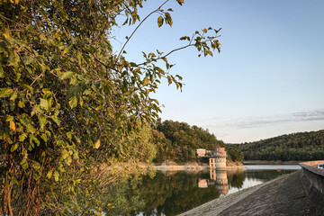 Obraz premium Panoramic view of Garasko Jezero, Lake Garas, dam near Arandjelovac, Serbia. The reservoir mirrors hills and the intake tower, with the embankment revealing the structure within the natural setting.