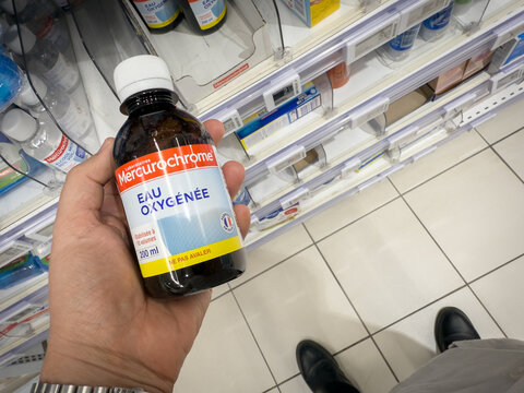 HYERES, FRANCE - SEPTEMBER 27, 2025: A bottle of Mercurochrome eau oxygenee, hydrogen peroxide, held in a supermarket aisle in Hyeres. It's a common French first aid disinfectant sold over the counter