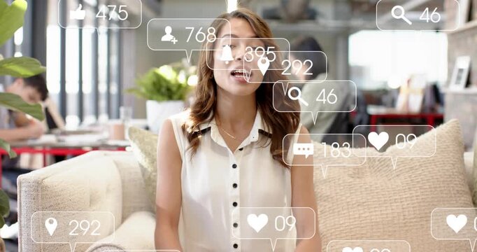 Woman sitting sofa in office speaking starting social icons moving across face or torso boosting rea