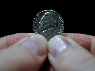 American Nickel Coin Held Between Fingers