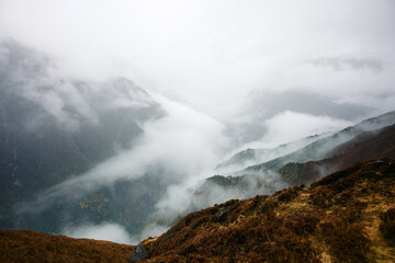 Clouds cover valleys in mountains during late morning hours with mist and fog creating a unique landscape