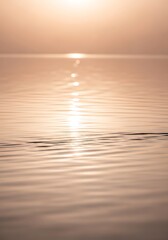 Serene expanse of water reflecting soft sunlight creating a tranquil mood scape reminiscent of dawn or dusk lighting