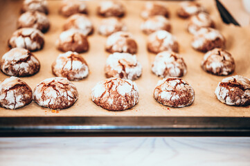 Chocolate crinkle cookies on metal tray after oven