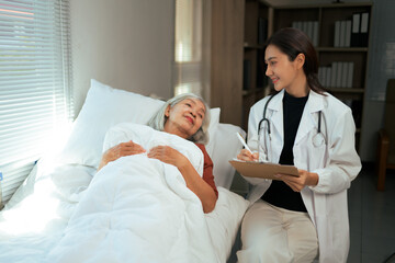 Obraz premium Doctor consulting elderly patient in hospital bed