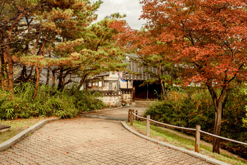 Namsangol Hanok Village, Seoul, South Korea, 04.10.2015: A serene pathway surrounded by autumn foliage in Seoul, Korea, leading towards traditional architecture