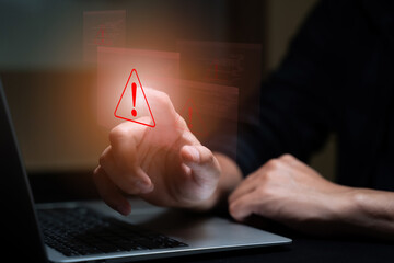 Businessman pressing laptop keyboard with glowing red system warning alert sign. Concept of cybersecurity risk, computer error, data protection failure, digital system security breach in technology.