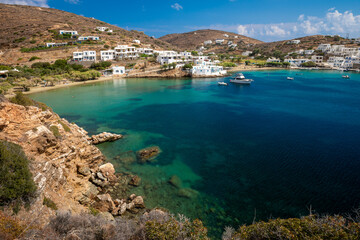 Obraz premium View from cliff trail across the calm turquoise waters of Vilcho beach to Faros on the greek island of Sifnos