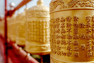 Jeju Islands, South Korea, 10.10.2015: Buddhist temple. Close-up of intricately designed golden prayer wheels in Jeju Island, South Korea, symbolizing peace and spirituality