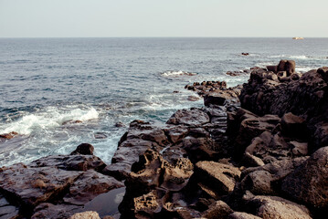 Coastal view of Jeju Island, South Korea, showcasing rocky shores and gentle waves, perfect for nature lovers and travelers