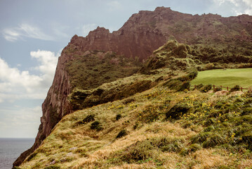 Seongsan Ilchulbong, Jeju Islands, South Korea,  An impressive view of the volcanic landscape on Jeju Island, showcasing steep cliffs and vibrant vegetation