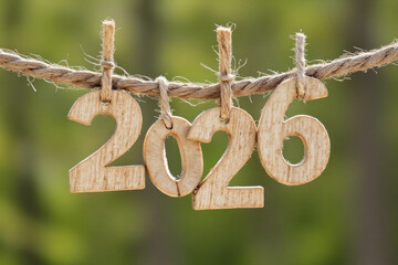 Number 2026 on hanging natural wooden blocks on a rope for the concept of welcoming and celebrating the new year 2026. 2026 new year background.
