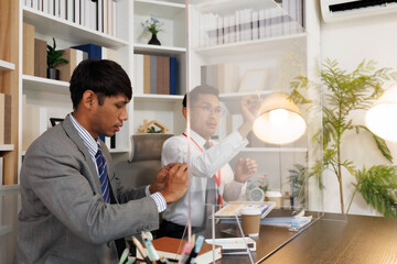 Obraz premium Two male employees in suits are designing a business plan, discussing various plans in their office, and one is drawing on a whiteboard. The scene looks cheerful and fun.