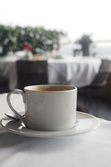 Coffee cup on a table in a cozy cafe by the sea