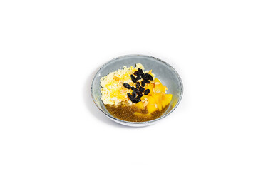 Healthy Breakfast Bowl with Cottage Cheese, Mango, Chia Seeds, Raisins, and Peanuts on a White Background