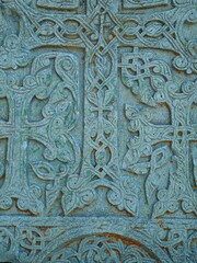 a close-up of an ancient carved stone doorway or wall fragment with rich religious carvings and intricate patterns.