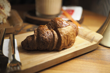 Freshly baked croissant on a wooden board at a cafe