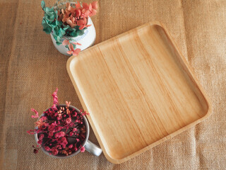 Dried flowers placed in a cup on a wooden tray create a warm, vintage-inspired scene with rustic textures and natural charm. Perfect for food styling, hobby branding      
