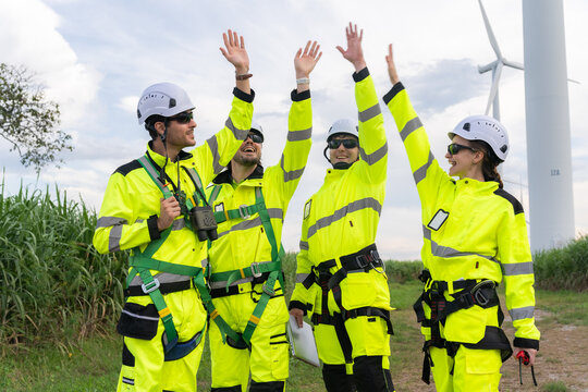Renewable energy engineers review wind farm project plans and data to analyze the efficiency and safety of wind power generation systems.
