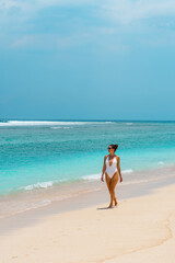 Model on a white sandy beach in swimwear