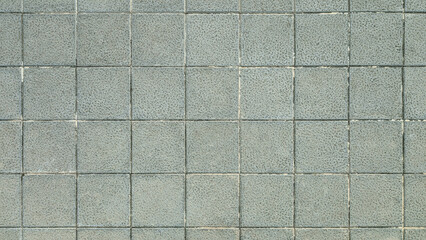 Textured concrete paving tiles for outdoor, patio, sidewalk and garden. Square slabs made of mixture of cement, sand, gravel and anti-slip, resistant and durable material. Public floor texture. 