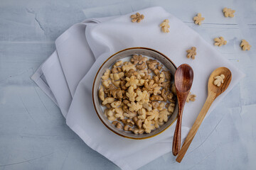 Bowl of maple leaf cereal with milk and wooden spoons on a white napkin