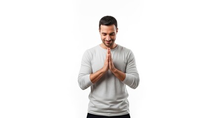 A man in a gray shirt with his hands clasped in prayer pose against a white background.