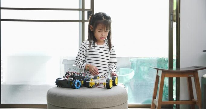Focused young girl assembling a robot, symbolizing childhood innovation and STEM learning