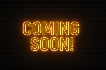 Bright yellow neon sign displaying bold coming soon message glowing strongly against a dark brick wall background for attention grabbing visuals