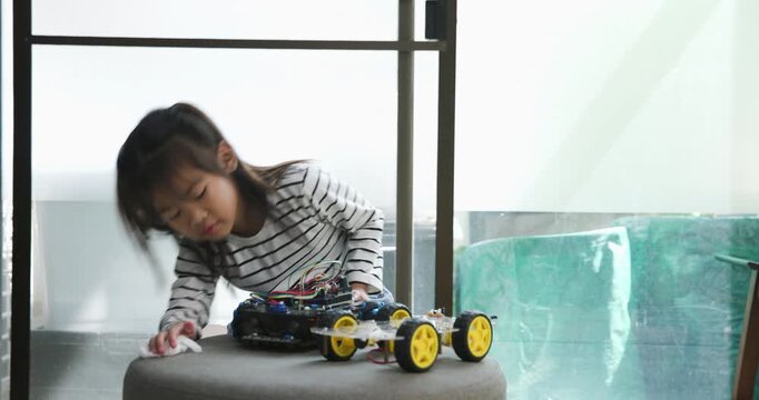 Focused young girl assembling a robot, symbolizing childhood innovation and STEM learning