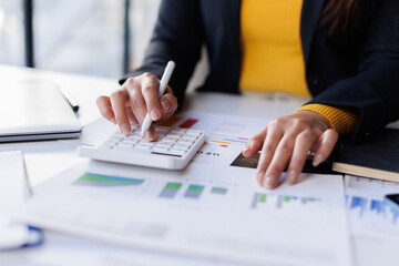 Business woman in formal suit working with monthly report balance sheet and yearly tax of accounting to verify the account by an authorized auditor