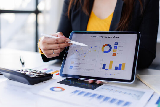 Business person analyzing financial statistics displayed on the tablet screen.

