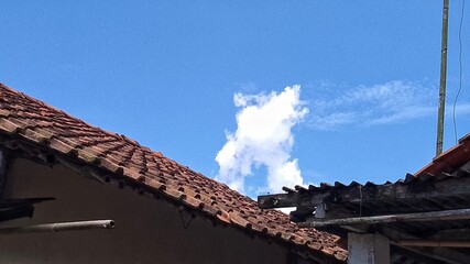 photo of a bright blue sky with unique roof tiles and clouds, suitable for use as background images, wallpapers, photo studios, weddings, food products, drinks, video backgrounds, illustrations, weath