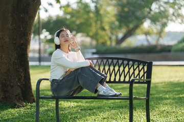 Young woman enjoying music relaxing in park