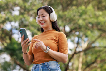 Young woman enjoying music with wireless headphones and smartphone