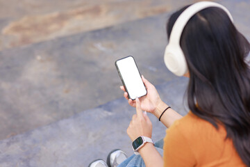 Woman listening music holding smartphone with blank screen