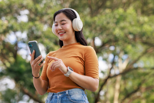 Young woman enjoying music with wireless headphones and smartphone