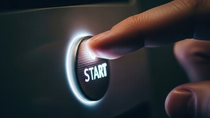 A finger presses a glowing "START" button, illuminating the surrounding metal surface