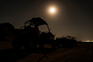 Buggies and ATVs in Egyptian desert at night. Night riding and entertainment for tourists