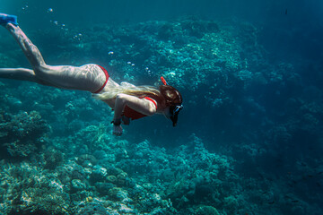 woman in snorkeling mask dive in sea lagoon to explore underwater world. Travel lifestyle in summer adventure camp. Swimming activities on beach vacations.