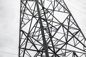Steel transmission tower against cloudy sky in industrial setting