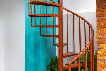 Elegant spiral staircase with blue accent wall and brick details