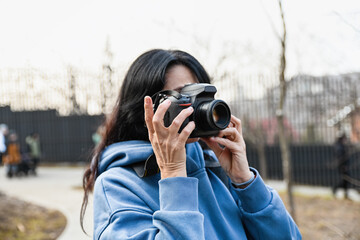 A woman enjoys her photography hobby outdoors capturing moments with calm focus expressing creativity personal interest and a sense of mindful freedom