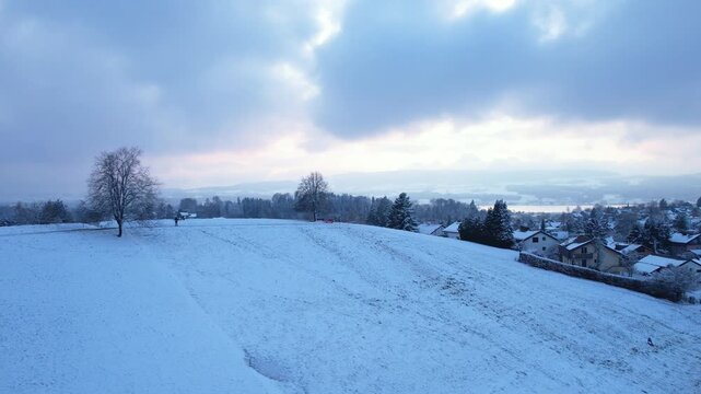 Aerial of a snowy landscape, revealing the city and lake of Uster, Switzerland
