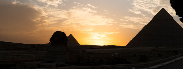 great sphinx and pyramids under bright sun. panoramic view of the Giza plateau with the great pyramids and the sphinx in the evening at sunset