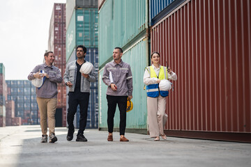 Walking engineer and worker team working in logistic terminal of container cargo, Diverse construction team in safety gear outdoors	