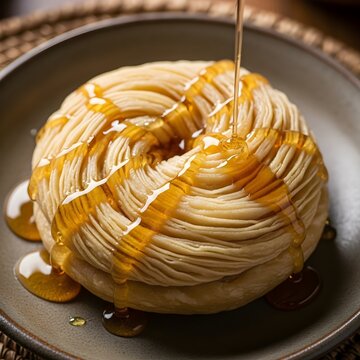 Macro shot of folded Malawah on a ceramic plate with glistening honey drizzle, delicate folds highlighted, shallow depth of field, rustic Omani kitchen, documentary style.