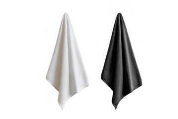 Two elegantly draped towels. one white and one black. hang symmetrically against a minimalist white wall. their textures and colors. ideal for home decor or textile design inspiration