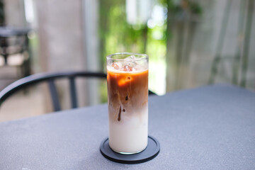A glass of iced latte coffee on the table in cafe
