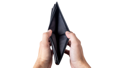 An empty black wallet is held open by two hands showing its interior with no money visible in the image solid white background and no background